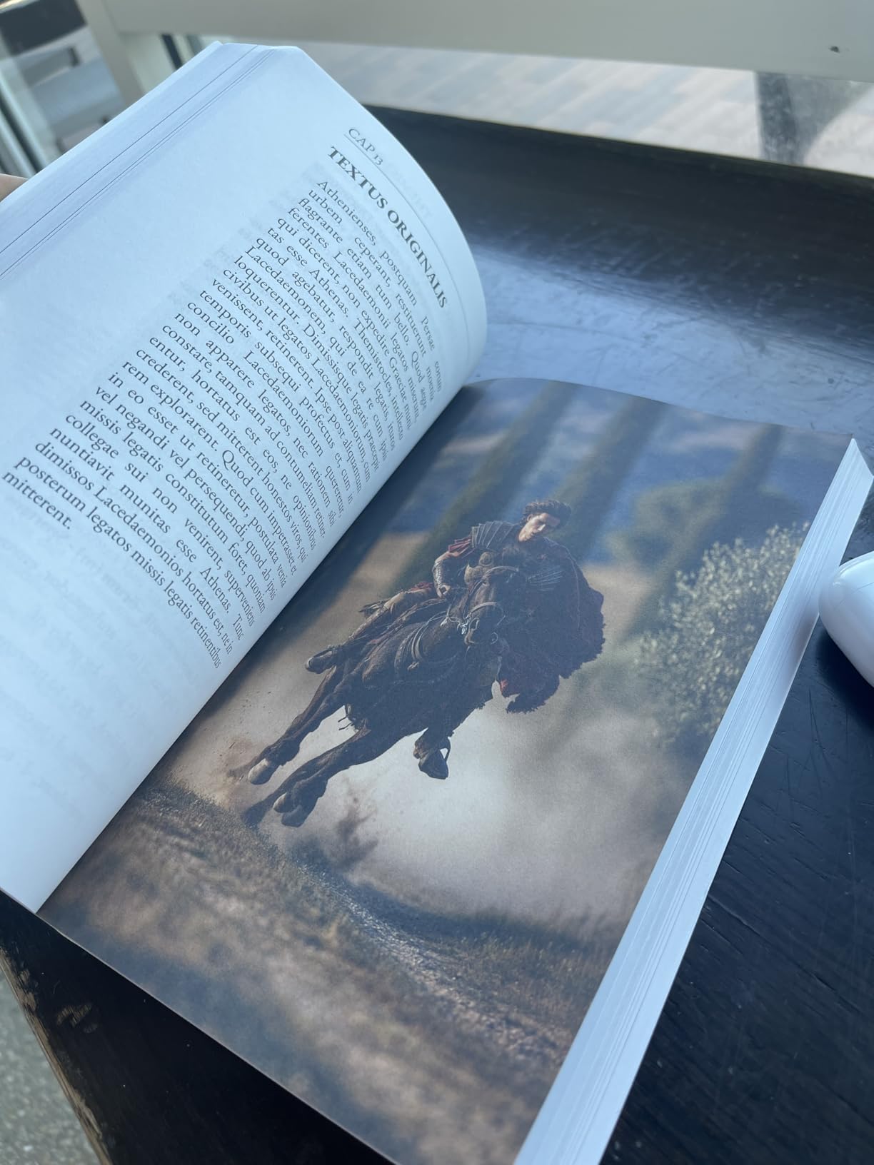 Reader photo of an open Strategemata paperback showing Latin text and a Roman cavalry illustration